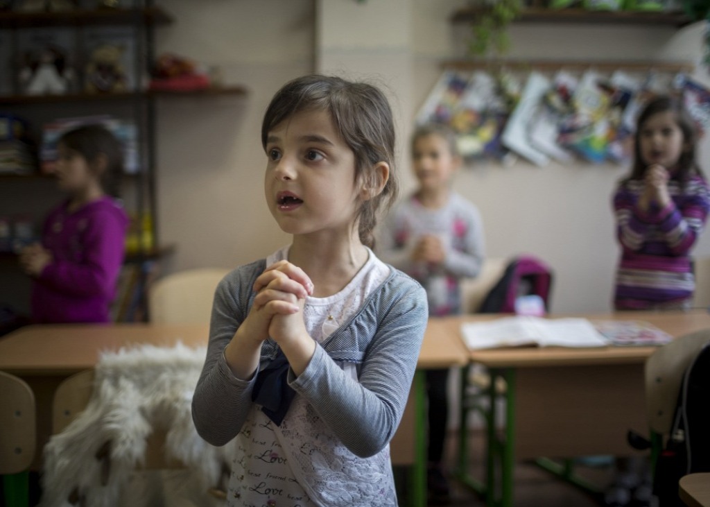 Gyerekek hittanórán a kárpátaljai Beregszászon. Noha az iskolák fenntartása az ukrán állam feladata, ez korántsem jelent garanciát a zavartalan működésre. Fűtőanyaghiány miatt telente akár hosszabb időszakokra is bezárhatnak egy-egy intézményt | Fotó: MTI/Mohai Balázs